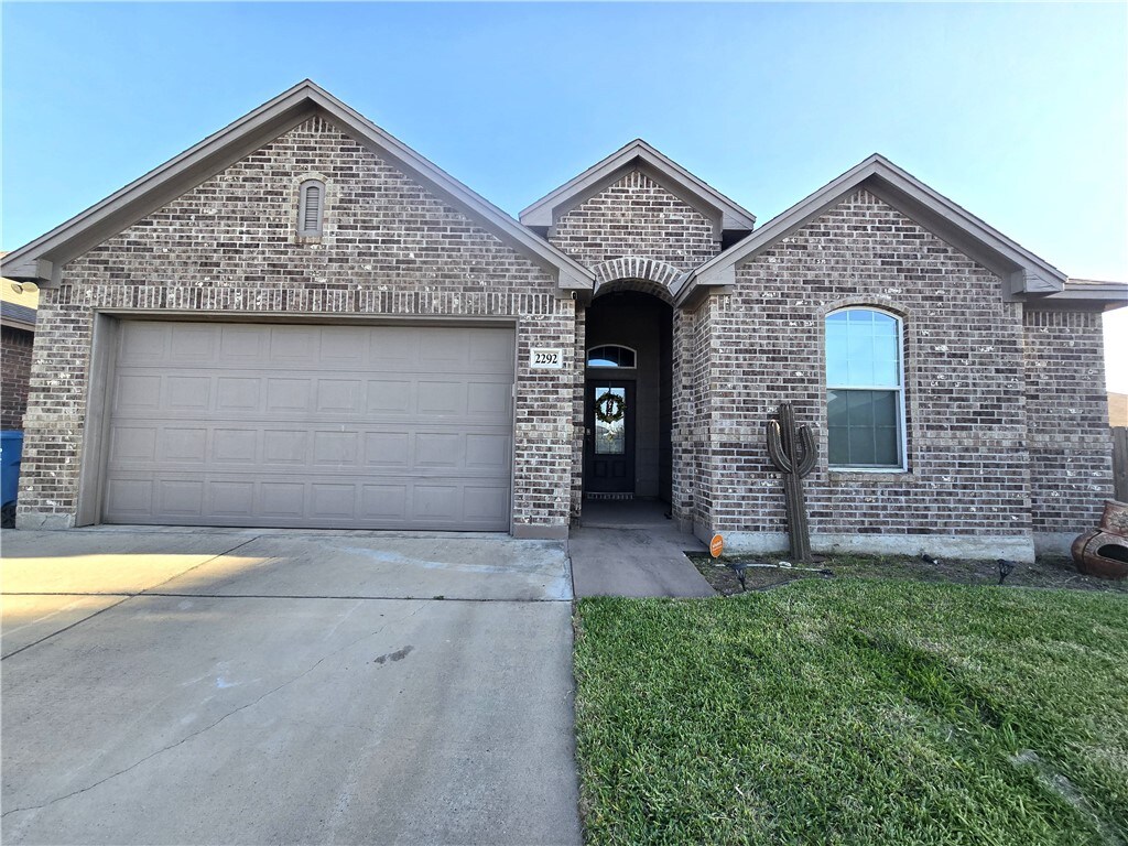 2292 Tallow Dr, Portland, TX 78374 - french country style house with brick siding, a front lawn, a garage, and concrete driveway