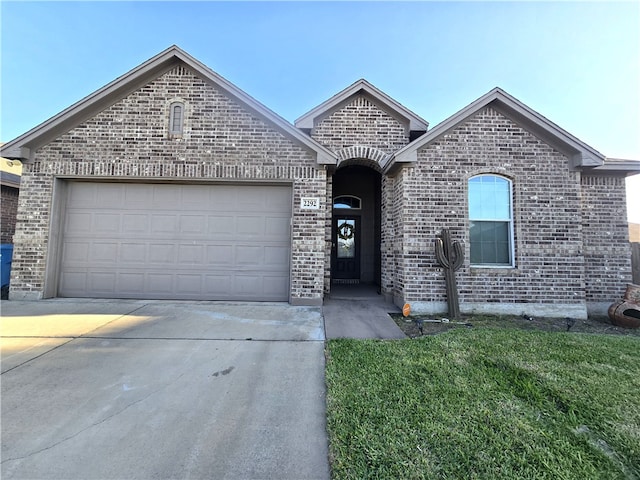 2292 Tallow Dr, Portland, TX 78374 - french country style house with brick siding, a front lawn, a garage, and concrete driveway