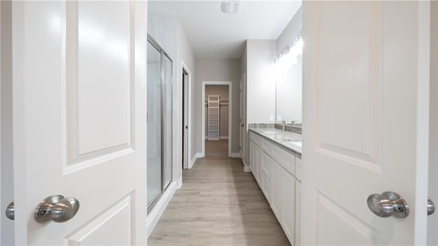 bathroom featuring wood-type flooring, vanity, and walk in shower