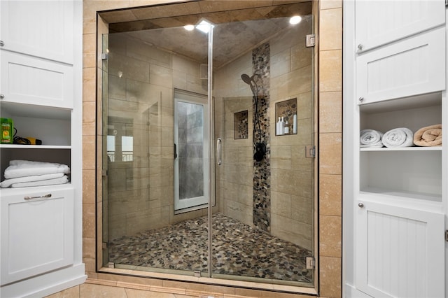 bathroom featuring tile patterned floors and a shower with shower door