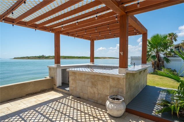 view of patio featuring a water view and a pergola