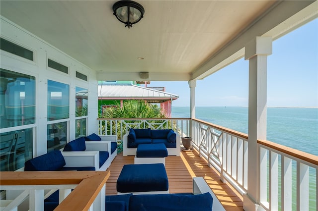 balcony with an outdoor living space and a water view