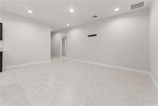 unfurnished room with baseboards, visible vents, and recessed lighting