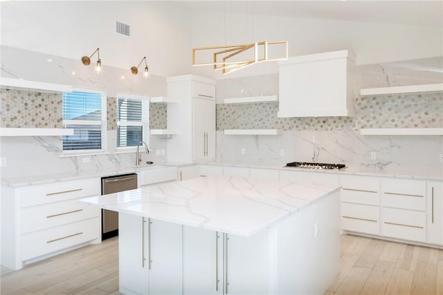 kitchen featuring visible vents, a kitchen island, open shelves, decorative backsplash, and appliances with stainless steel finishes