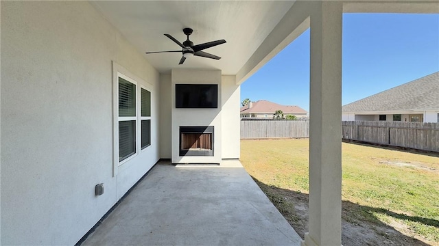 view of patio / terrace with a fenced backyard, ceiling fan, and an outdoor fireplace