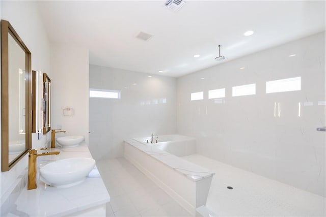 bathroom featuring a bath, visible vents, a walk in shower, and a sink