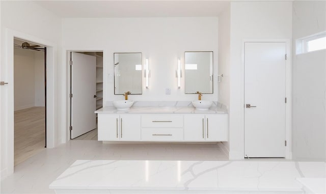 bathroom with double vanity, a ceiling fan, and a sink