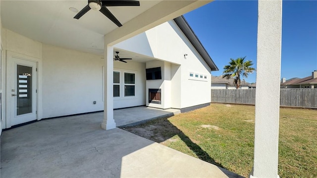 view of yard featuring a patio area, ceiling fan, and fence