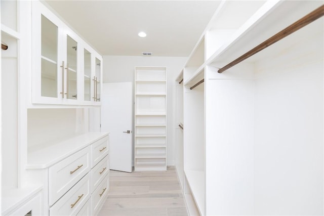 spacious closet with light wood-style floors and visible vents