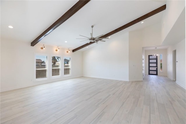 unfurnished living room featuring a ceiling fan, baseboards, light wood-style flooring, vaulted ceiling with beams, and recessed lighting