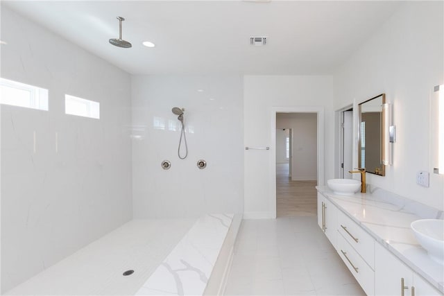 full bath with a sink, visible vents, walk in shower, and double vanity