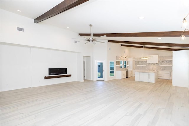 unfurnished living room with visible vents, lofted ceiling with beams, a fireplace, light wood-style floors, and a ceiling fan