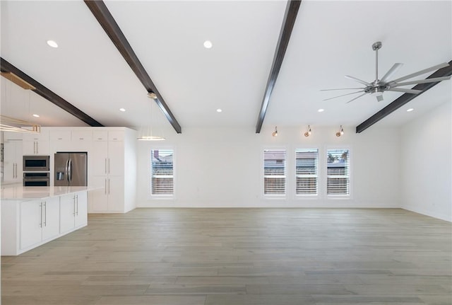 unfurnished living room featuring lofted ceiling with beams, light wood-type flooring, plenty of natural light, and ceiling fan