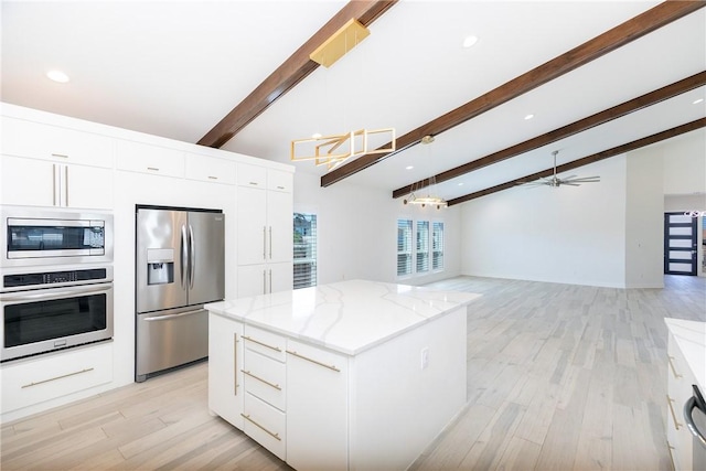 kitchen featuring modern cabinets, light stone counters, a kitchen island, white cabinetry, and appliances with stainless steel finishes