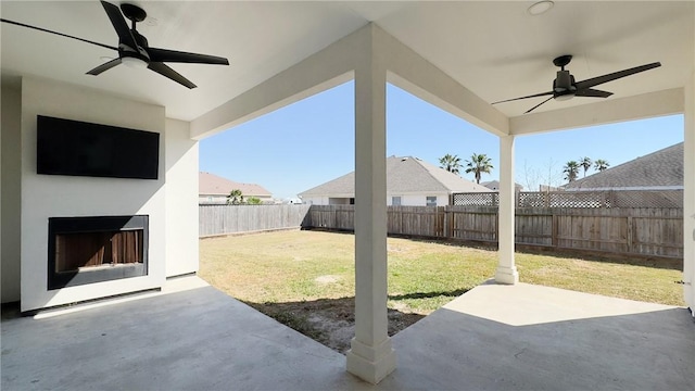 view of patio featuring exterior fireplace, a fenced backyard, and ceiling fan