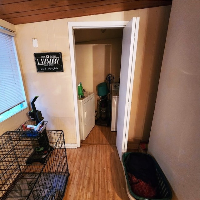 hall with light hardwood / wood-style flooring and independent washer and dryer