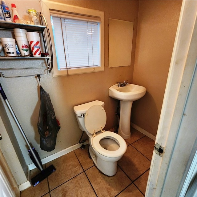 bathroom featuring toilet, sink, and tile patterned floors