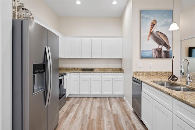 111 Great Chagos, Rockport, TX 78382 - kitchen featuring appliances with stainless steel finishes, a sink, white cabinetry, light wood finished floors, and recessed lighting