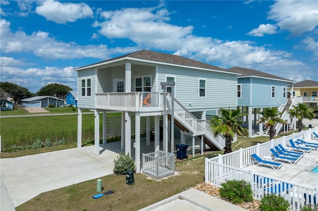 111 Great Chagos, Rockport, TX 78382 - rear view of property featuring a carport, driveway, a shingled roof, and stairs