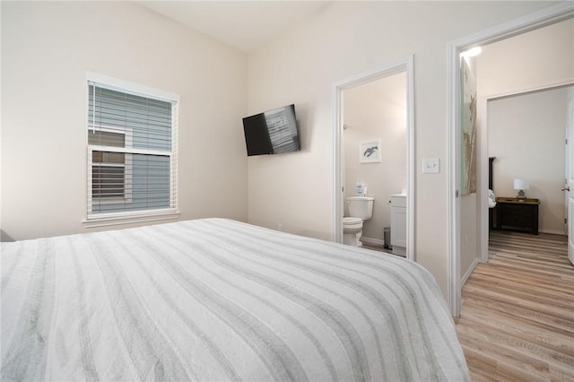 111 Great Chagos, Rockport, TX 78382 - bedroom with wood finished floors, ensuite bathroom, and baseboards