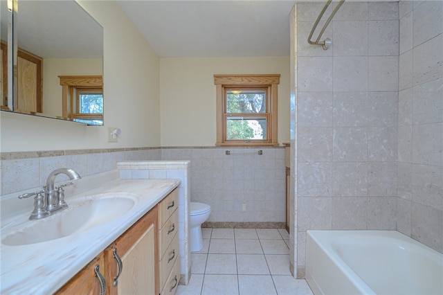 full bathroom featuring toilet, tile patterned floors, tile walls, tiled shower / bath combo, and vanity