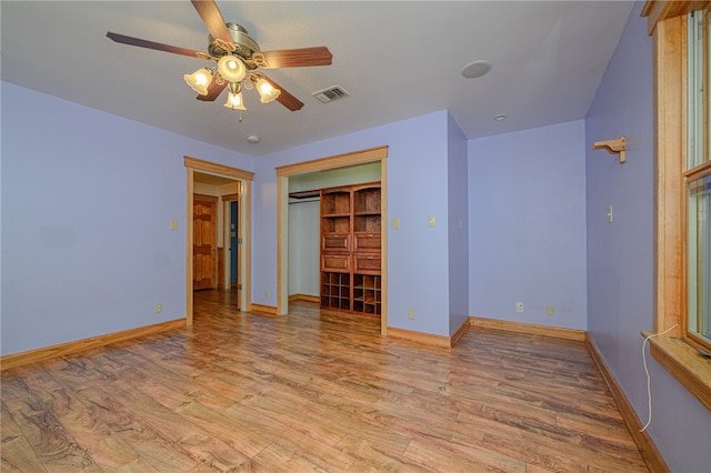 unfurnished bedroom featuring light hardwood / wood-style floors, ceiling fan, and a closet