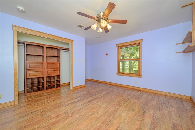 unfurnished bedroom featuring light hardwood / wood-style floors, ceiling fan, and a closet