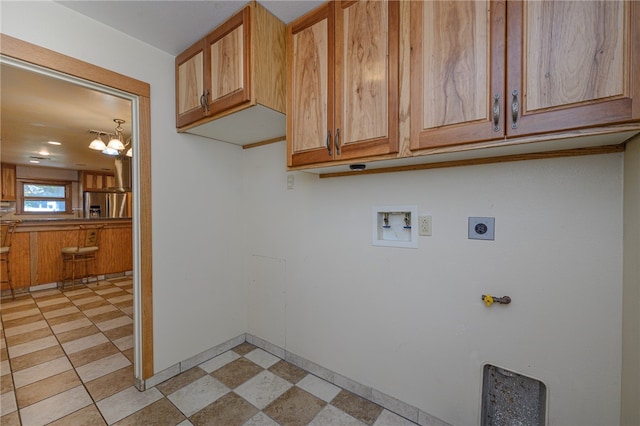 clothes washing area with hookup for an electric dryer, washer hookup, cabinets, and a notable chandelier