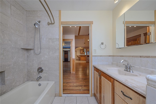 bathroom featuring tile walls, vanity, tiled shower / bath, and hardwood / wood-style floors