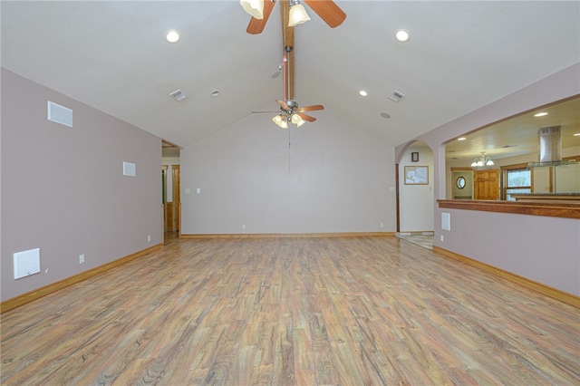 unfurnished living room featuring ceiling fan with notable chandelier, light hardwood / wood-style flooring, and vaulted ceiling