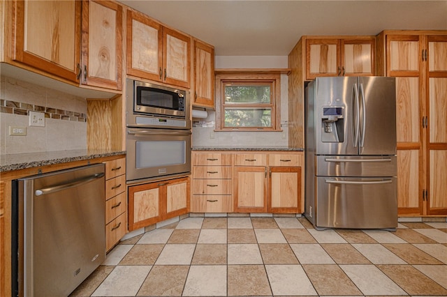 kitchen featuring light stone countertops, backsplash, light tile patterned flooring, and stainless steel appliances