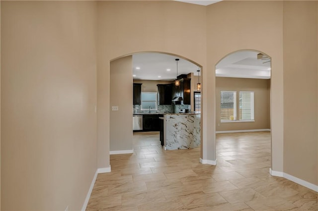 1530 Bay Moon Ct, Corpus Christi, TX 78417 - hall featuring arched walkways, baseboards, a sink, and a towering ceiling