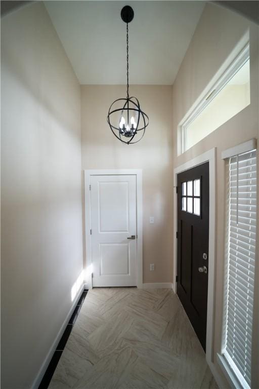 entryway with an inviting chandelier, light parquet floors, and a towering ceiling