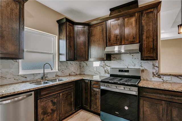 1530 Bay Moon Ct, Corpus Christi, TX 78417 - kitchen featuring appliances with stainless steel finishes, under cabinet range hood, a sink, light stone countertops, and dark brown cabinetry