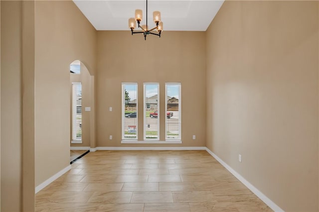 1530 Bay Moon Ct, Corpus Christi, TX 78417 - unfurnished room with a chandelier, baseboards, a towering ceiling, and arched walkways