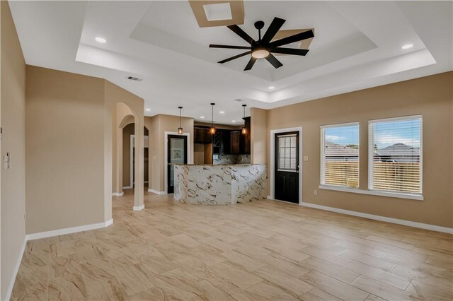 1530 Bay Moon Ct, Corpus Christi, TX 78417 - unfurnished living room featuring a raised ceiling, a ceiling fan, arched walkways, baseboards, and recessed lighting