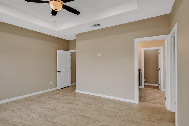 1530 Bay Moon Ct, Corpus Christi, TX 78417 - empty room featuring a tray ceiling, a ceiling fan, light marble finish floors, and baseboards