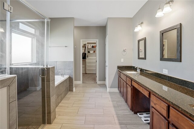 bathroom with vanity and shower with separate bathtub