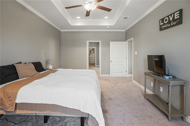 carpeted bedroom featuring ornamental molding, ceiling fan, and a raised ceiling