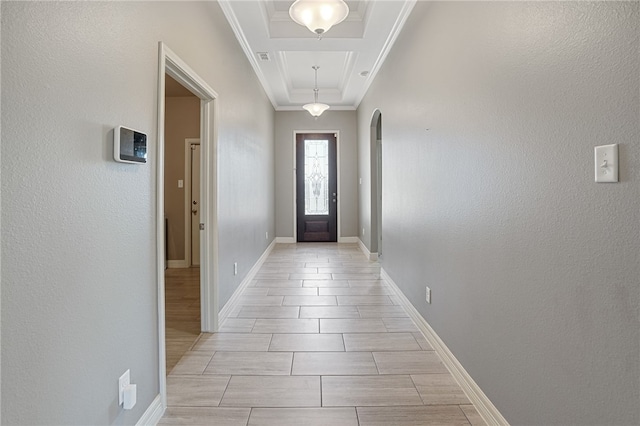 doorway to outside featuring a raised ceiling and crown molding