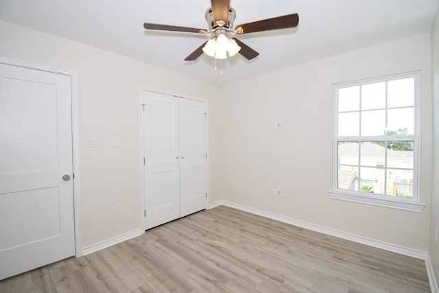 unfurnished bedroom with light hardwood / wood-style floors, ceiling fan, and a closet