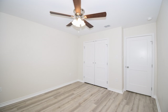 unfurnished bedroom featuring light wood-style floors, a closet, baseboards, and a ceiling fan