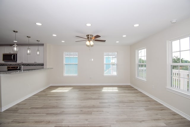 unfurnished living room featuring light wood-style flooring, recessed lighting, a ceiling fan, and baseboards