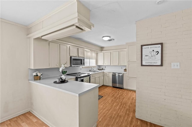 857 Belmeade Dr, Corpus Christi, TX 78412 - kitchen with appliances with stainless steel finishes, light wood finished floors, light countertops, a sink, and a peninsula
