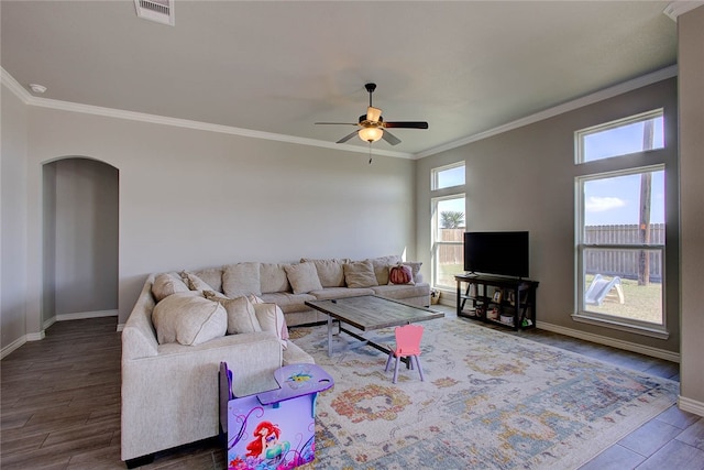 living room featuring ornamental molding, ceiling fan, a wealth of natural light, and dark hardwood / wood-style floors