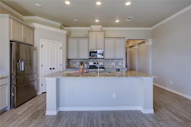 kitchen featuring light wood-type flooring, a center island with sink, and stainless steel appliances