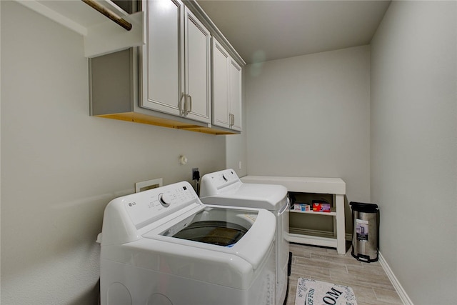 washroom featuring cabinets, washer and dryer, and light hardwood / wood-style floors