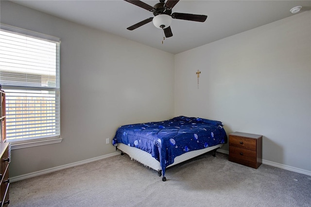 bedroom featuring ceiling fan, multiple windows, and light carpet