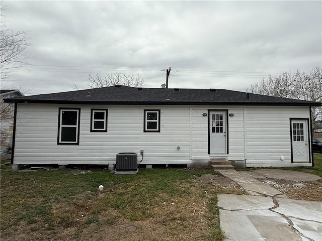 rear view of house with central AC unit, a yard, and a patio area