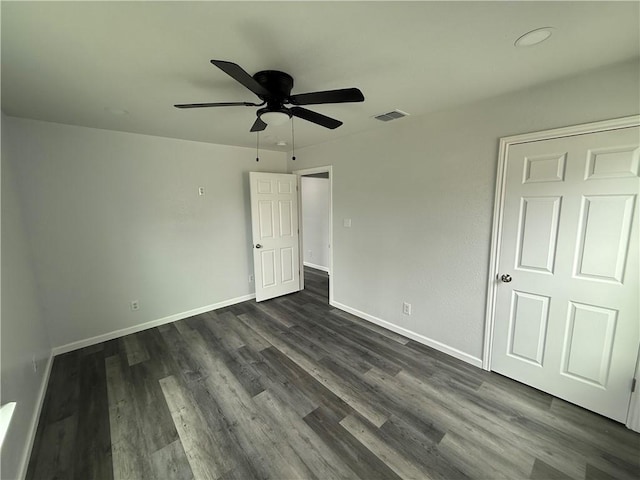 unfurnished bedroom featuring ceiling fan and dark hardwood / wood-style flooring